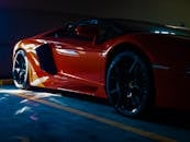 一辆充满活力的橙色跑车停在阳光明媚的车库里，尽显奢华与现代设计