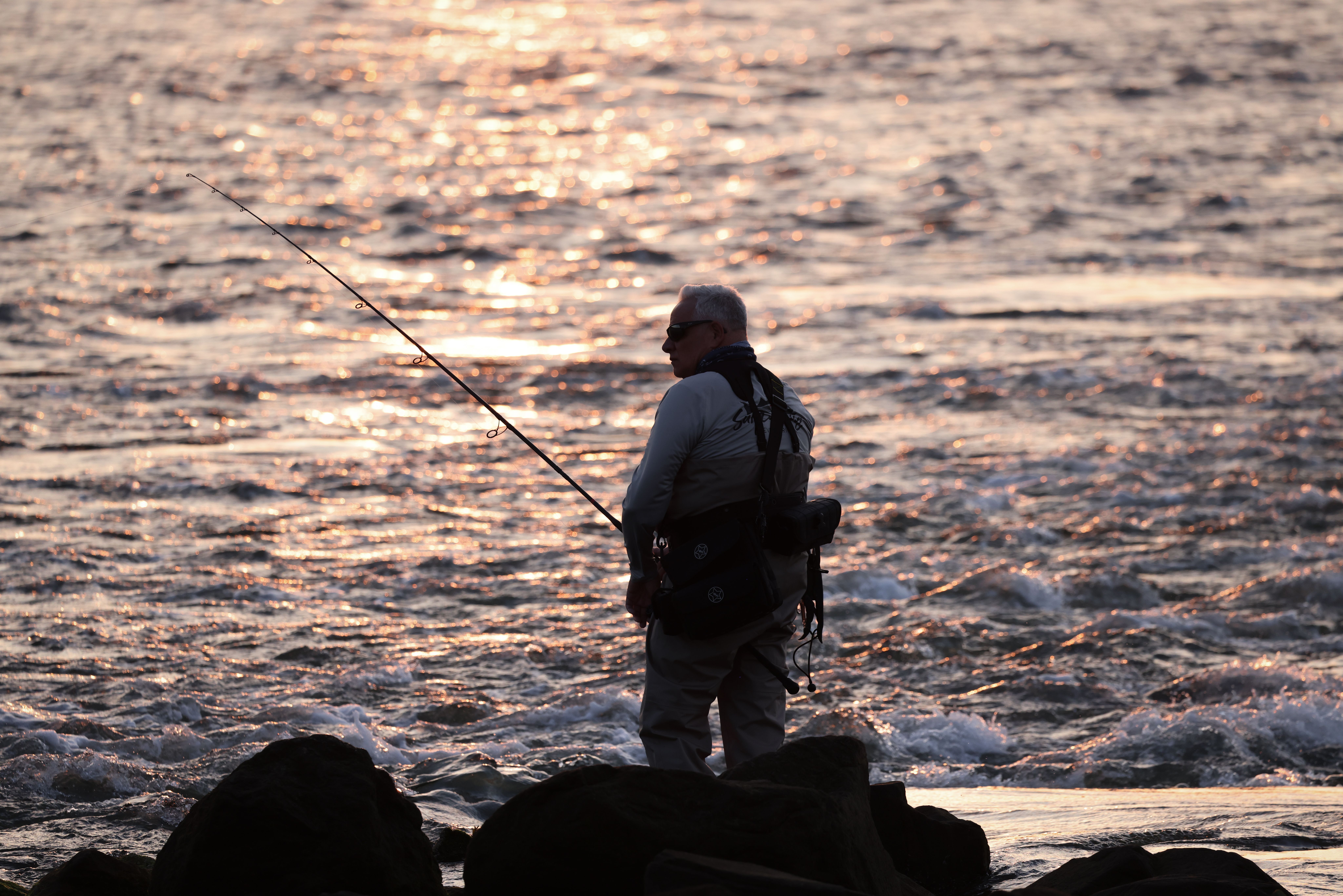Man fishing with bags on him