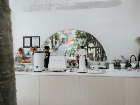 A sleek and modern coffee shop interior in Jawa Timur, Indonesia, featuring bar equipment.