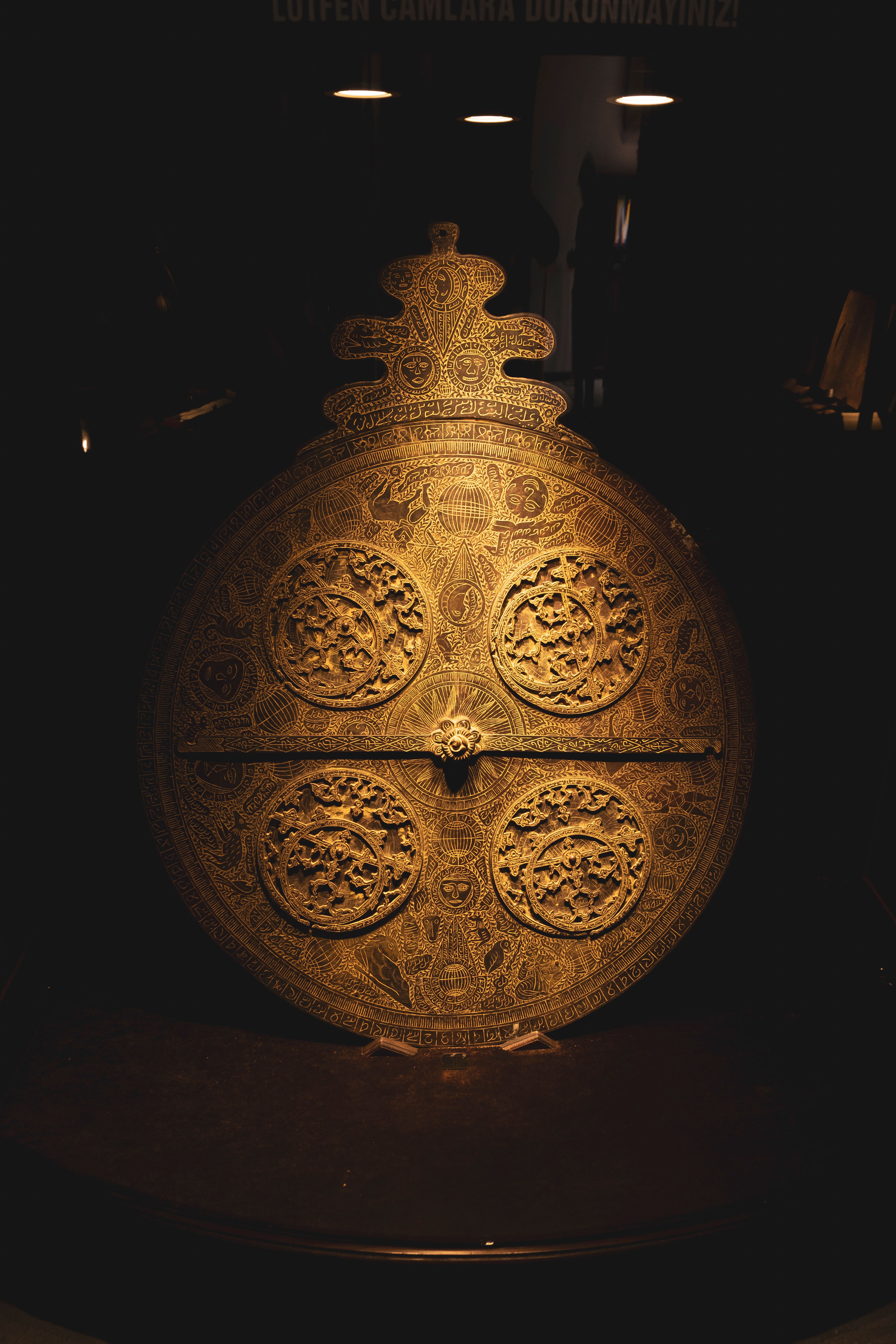 A detailed view of an ornately carved bronze fragment, representing the exquisite workmanship of ancient technological artifacts like the Antikythera mechanism.