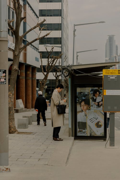 A man is standing at a bus stop
