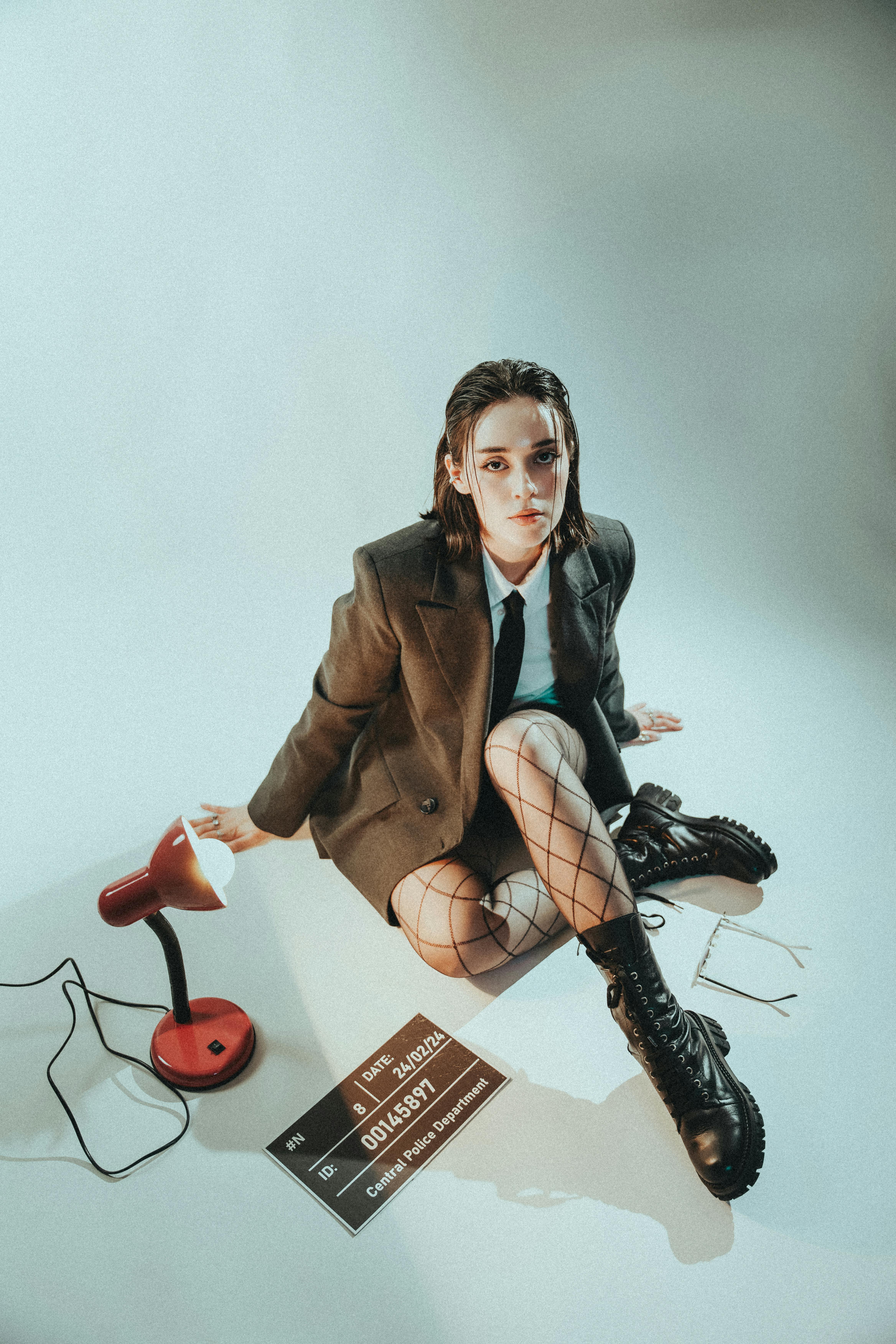 a woman sitting on the floor with a lamp and a microphone