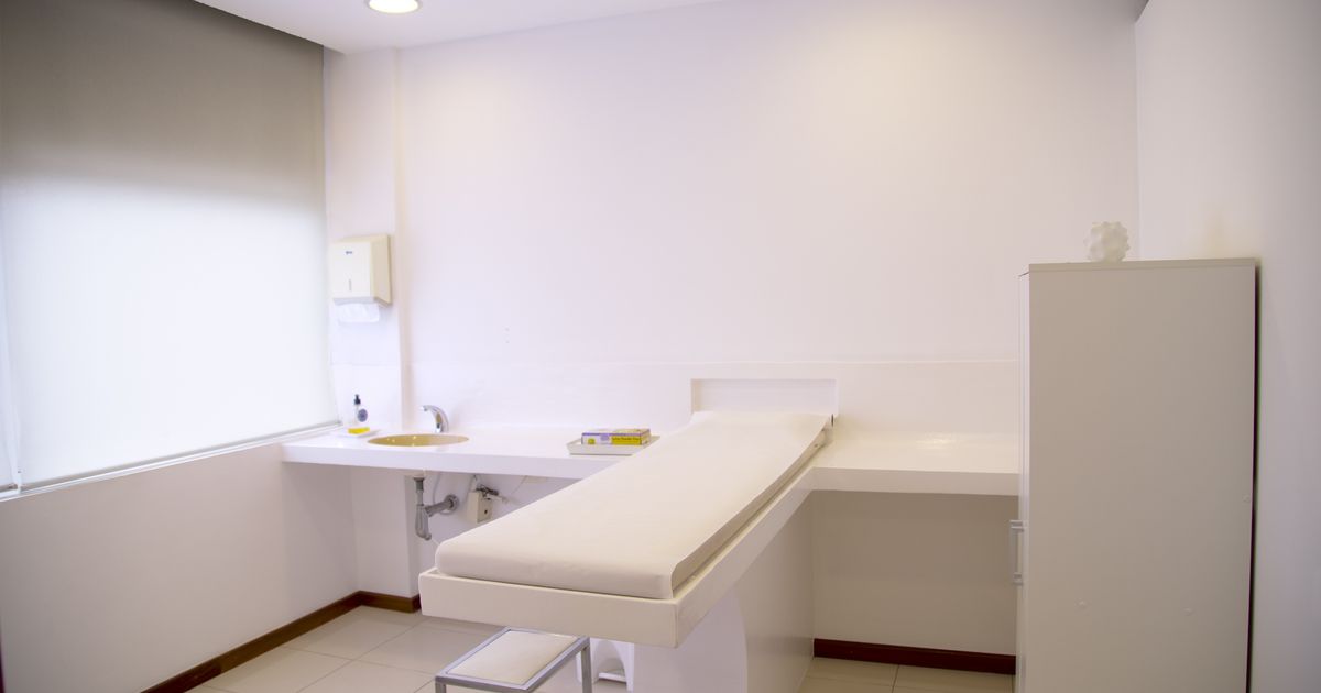 Minimalist clean clinic room with examination table