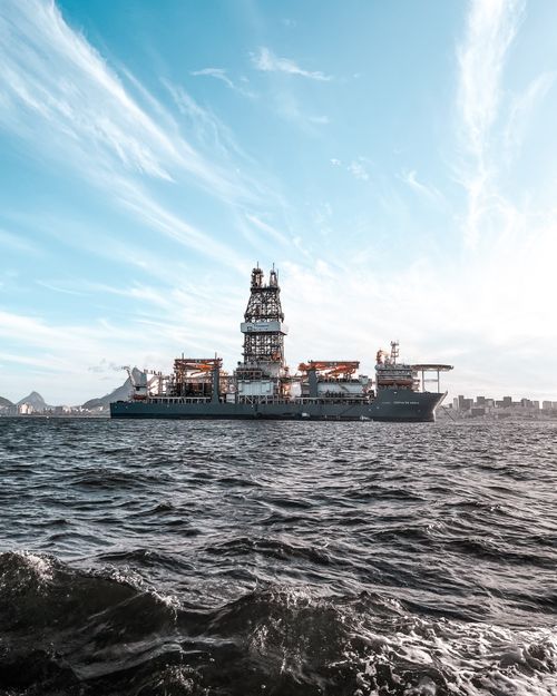 Free Large offshore oil rig ship on open sea with dramatic sky and skyline. Stock Photo