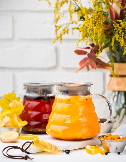 Free Colorful glass pitchers of autumn fruit infusions with berries and flowers. Perfect for a cozy fall setting. Stock Photo