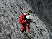 Two People Rappelling Near Grey Rocks