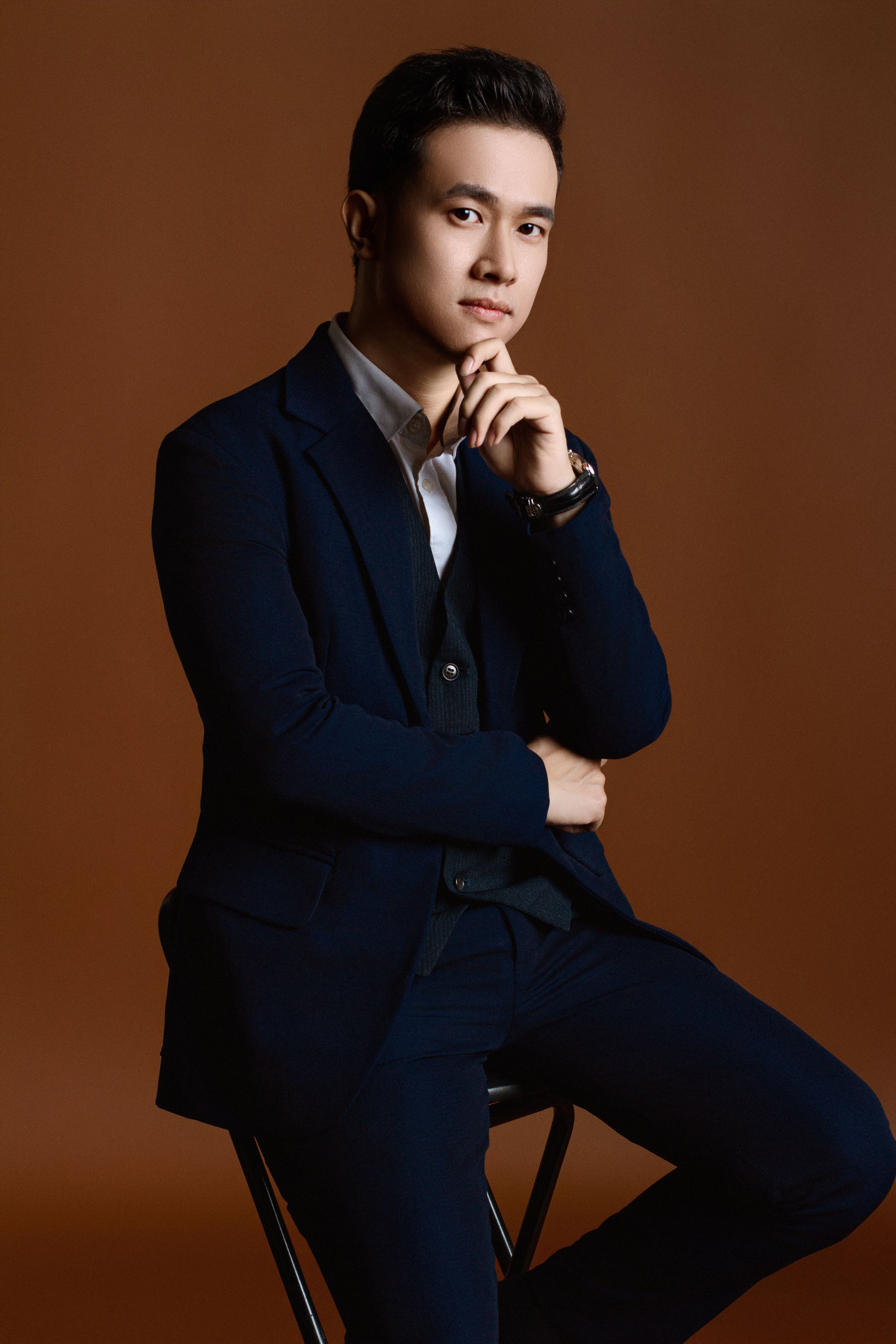 Sophisticated young man posing in a suit in a studio setting.