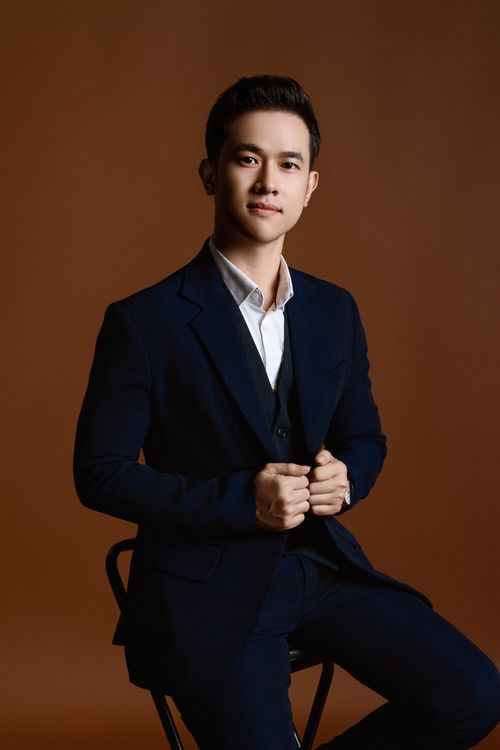 Free A young man in a formal suit poses confidently in a studio setting, showcasing fashion and elegance. Stock Photo