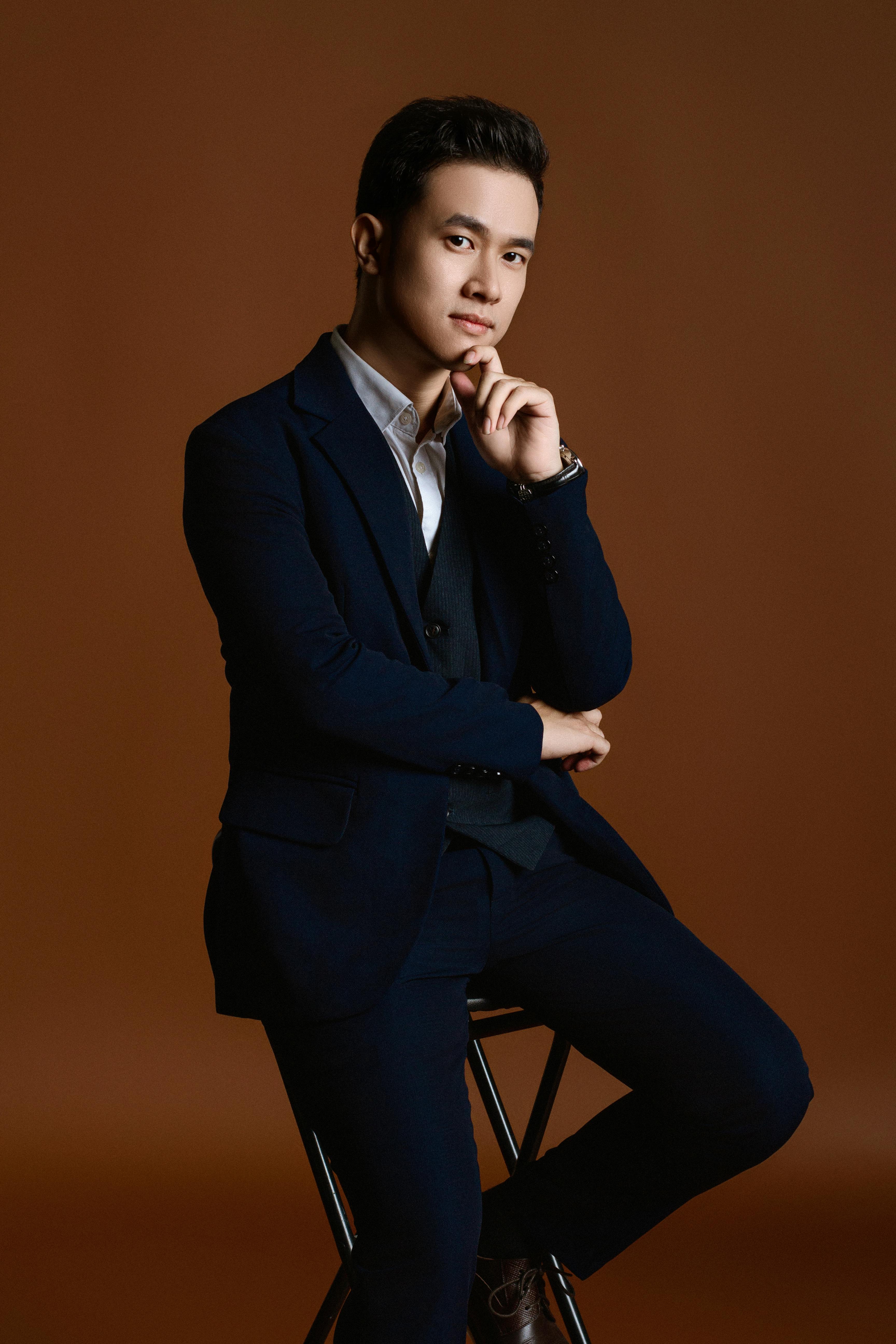 Professional portrait of a well-dressed young man in a suit, posing in a studio.