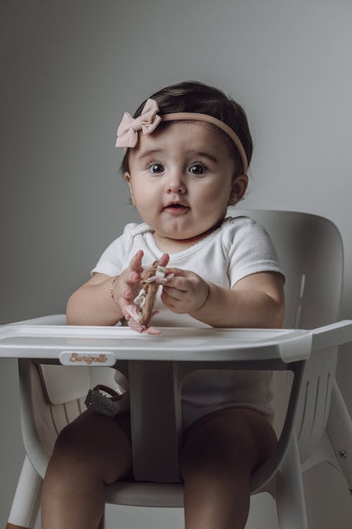 A baby girl sitting in a high chair