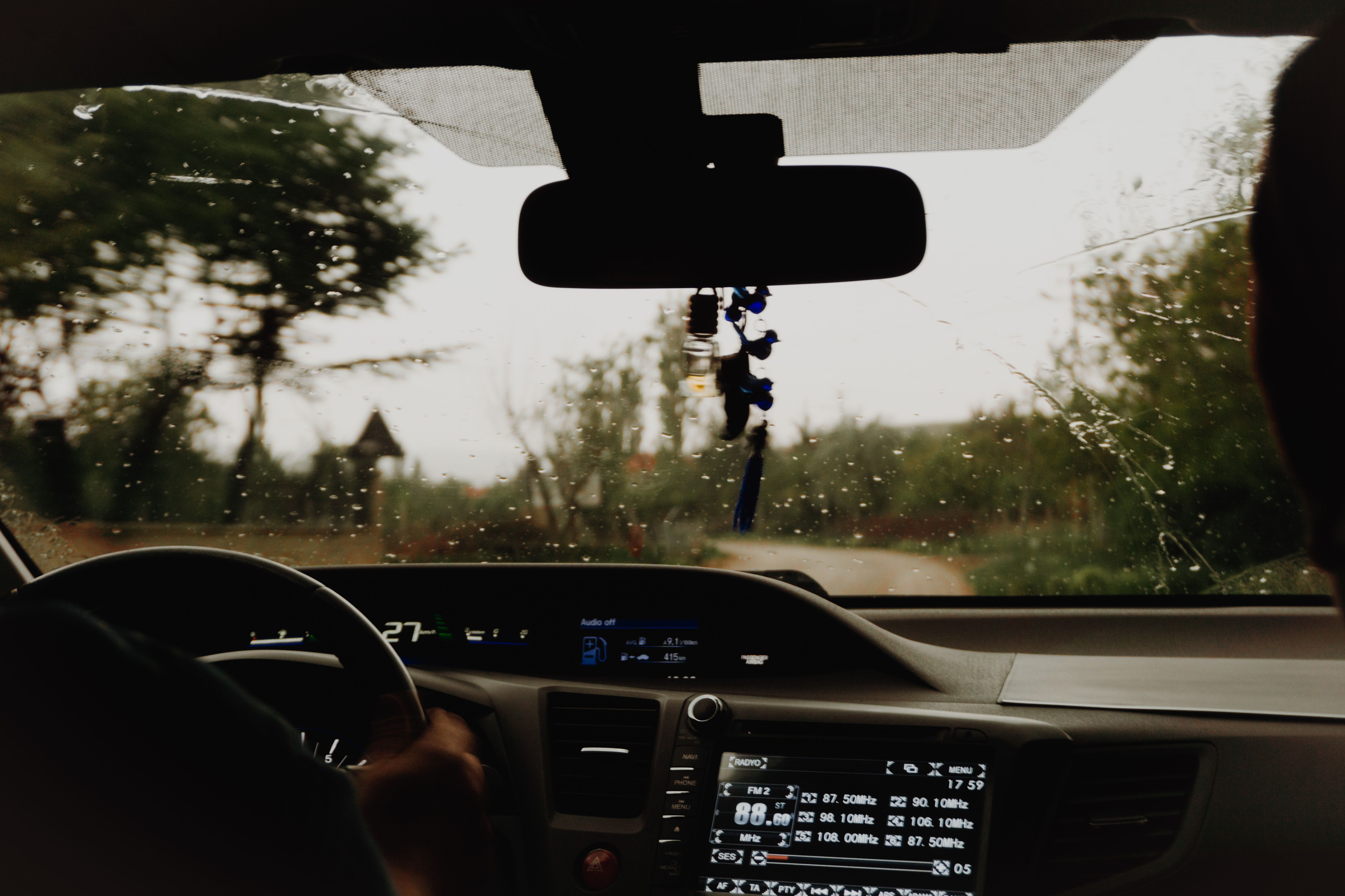 A man driving a car through a rainy day · Free Stock Photo