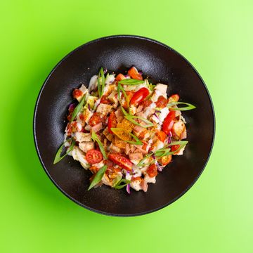 Colourful chicken and herb salad in a dark bowl, photo by Ali Dashti on Pexels