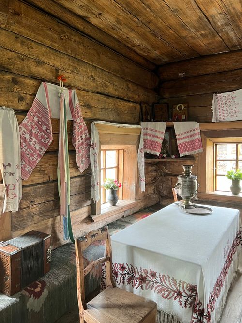 Free Cozy wooden cabin interior with vintage decor and traditional samovar on table. Stock Photo