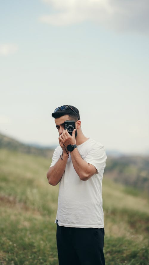 A Man Taking Pictures with a Vintage 35mm Film Camera