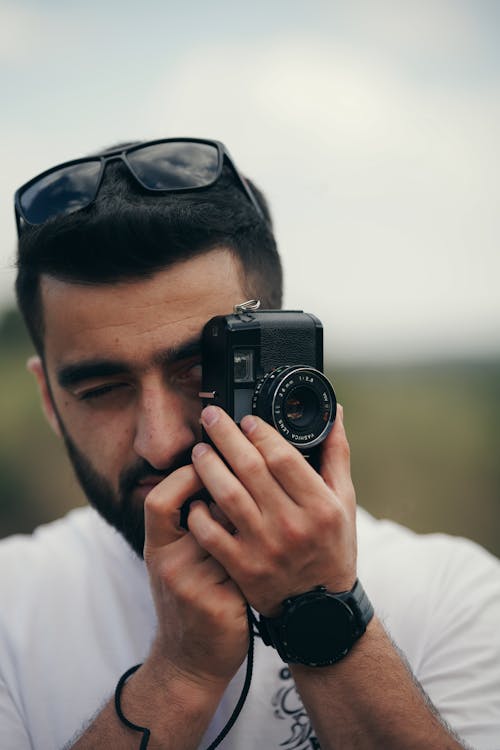 A Man Taking Pictures with a Vintage 35mm Film Camera