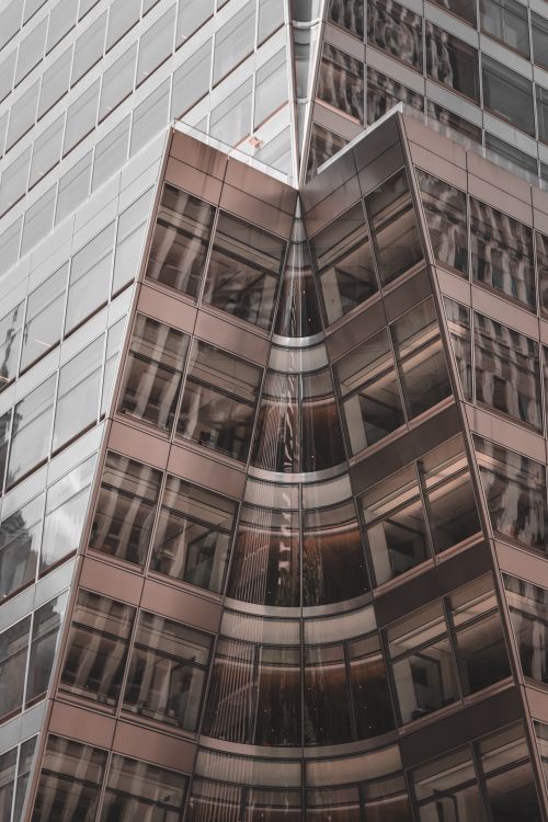 Free Modern office building with dynamic glass reflections in downtown. Stock Photo