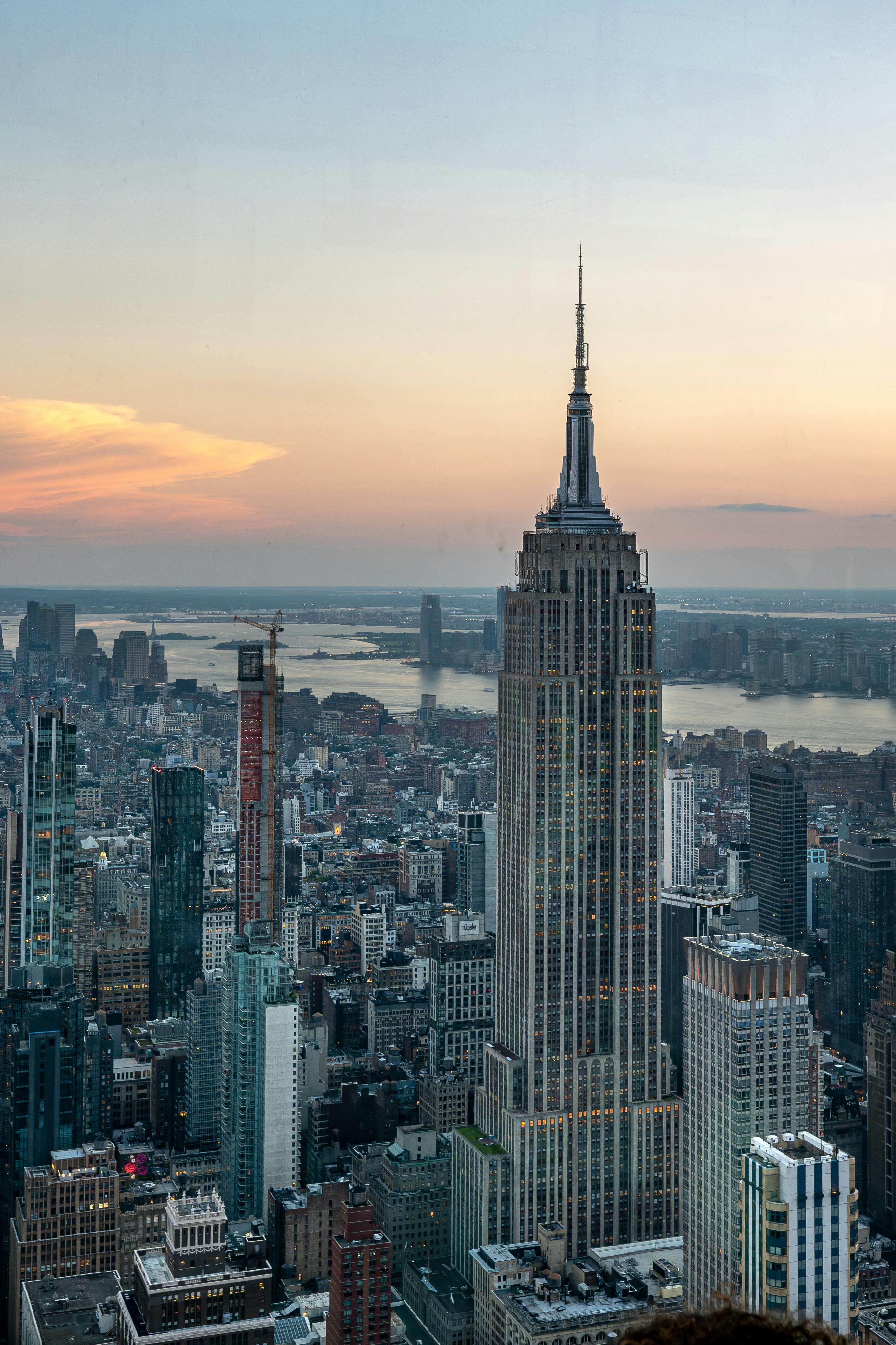 A stunning aerial view of New York City with the Empire State Building at sunset, showcasing the urban skyline.