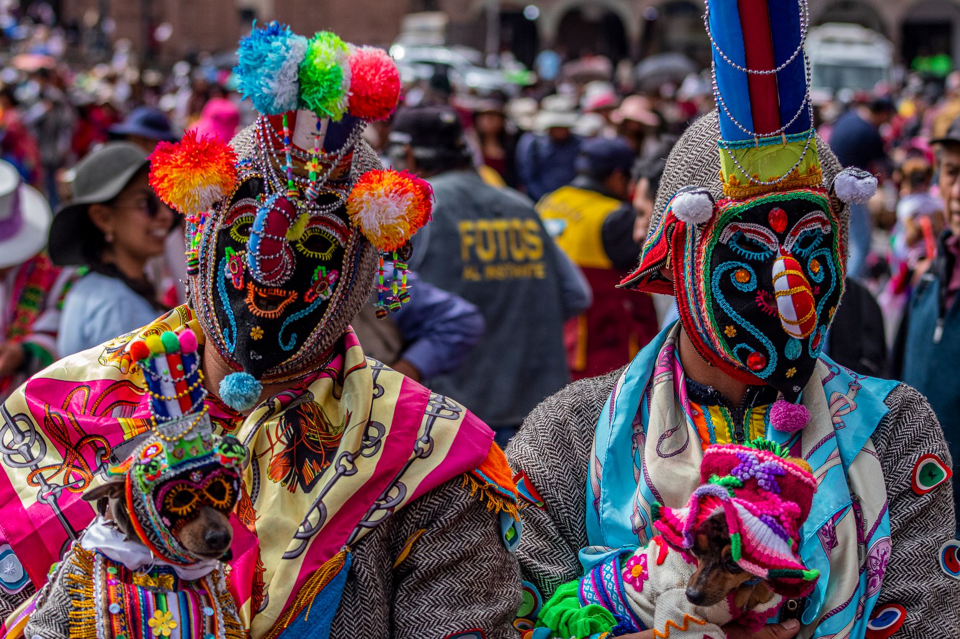 Colorful traditional costumes and masks at a parade in Cusco, Peru, showcasing cultural heritage.