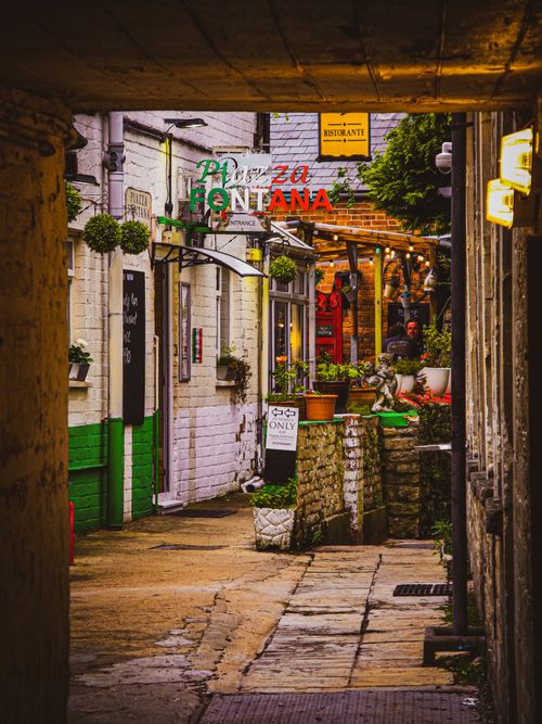 Free A vibrant alleyway lined with quaint restaurants and lively decor, inviting urban exploration. Stock Photo