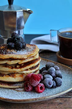 煎饼配浆果和咖啡，非常适合作为舒适的早餐享用