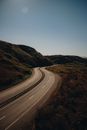Asphalt road running through hilly terrain in summer