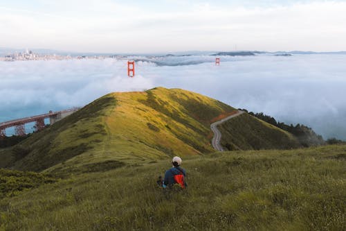Free Person Sitting On Grass Hill Near The Golden Gate Bridge In San Francisco d Stock Photo