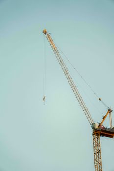 Imposing tower crane set against a clear blue sky in Ho Chi Minh City, Vietnam.