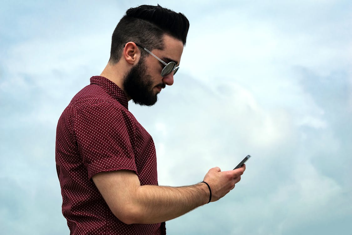 Selective Focus Photography of Man Holding Smartphone