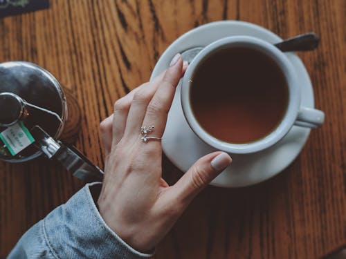 Free Person Touching a White Coffee Cup With Saucer Close-up Photography Stock Photo