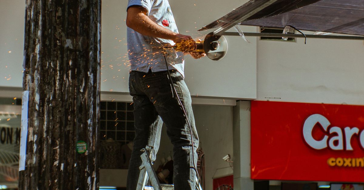 Person Using Angle Grinder Outdoors · Free Stock Photo