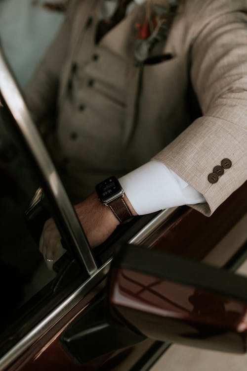 A man in a suit and tie sitting in a car