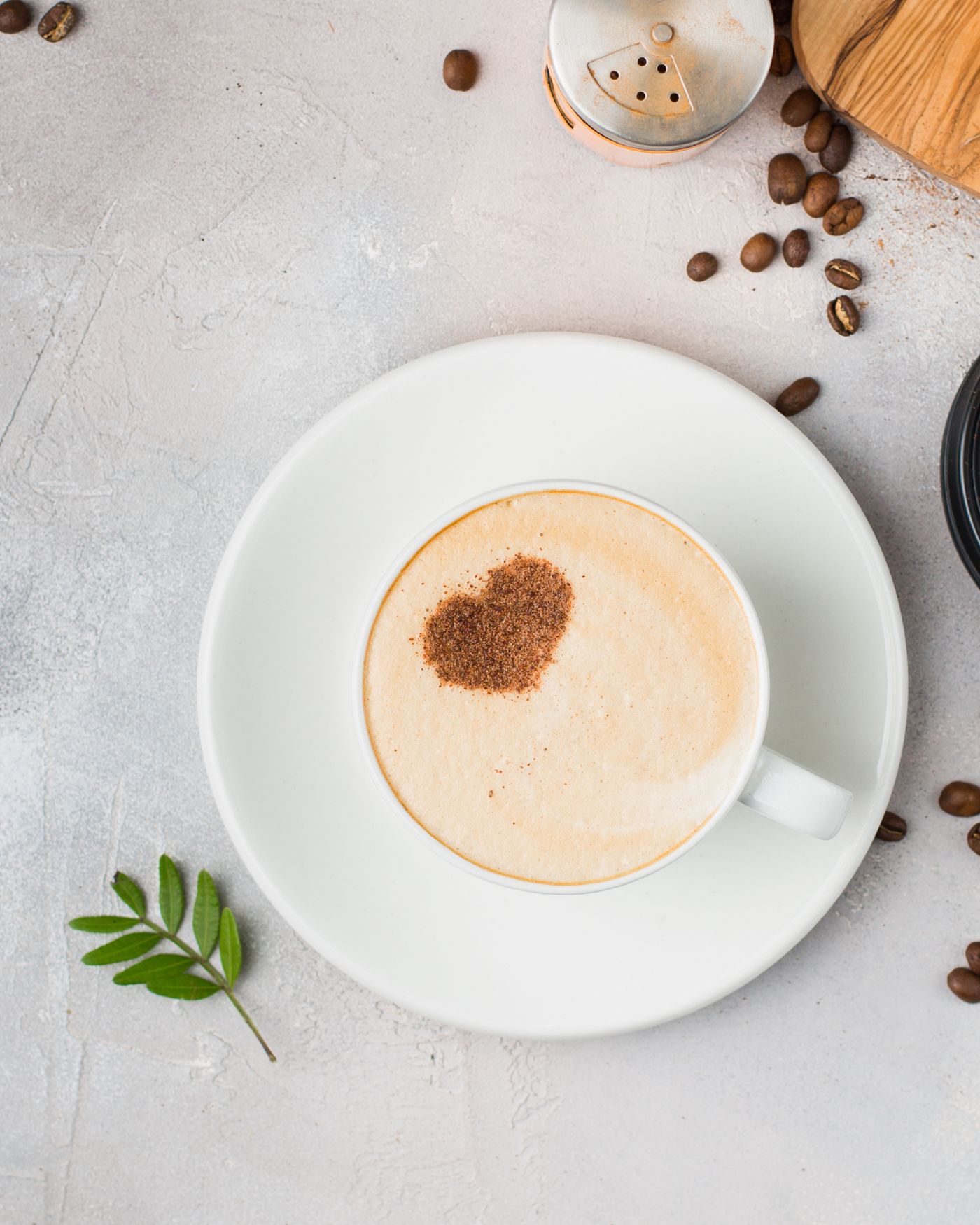 Taza amplia de café con mucha leche y un corazón de cacao en la superficie.