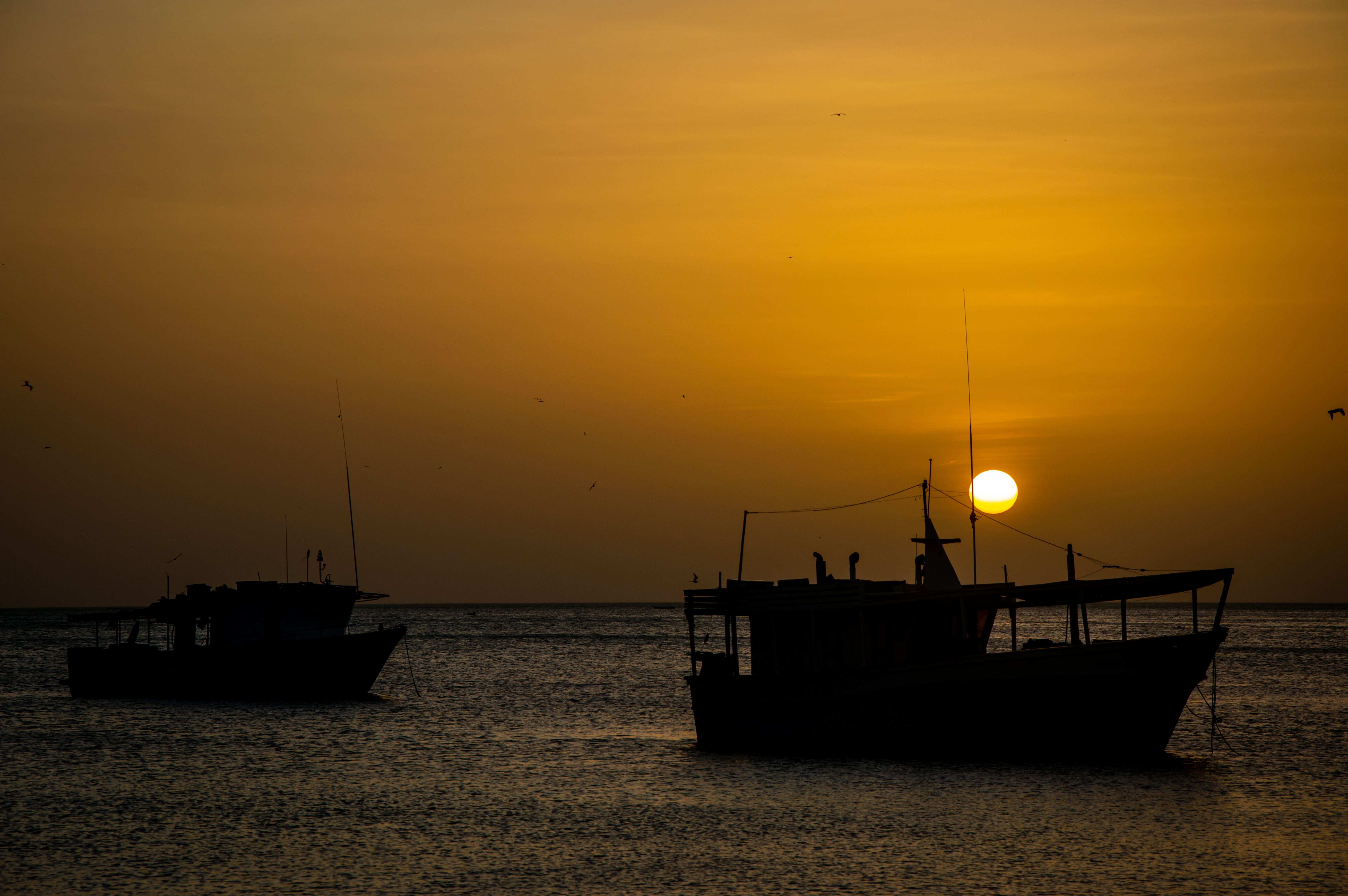 Silhouetted Boats on the Sea at Sunset · Free Stock Photo
