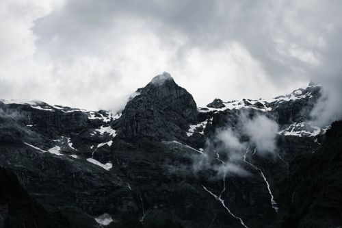 Free Snowy mountains and clouds create a dramatic scene in Sixt-Fer-à-Cheval, France. Stock Photo