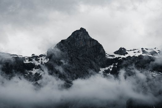 Majestic peaks of Sixt-Fer-à-Cheval in France enveloped in misty clouds under a dramatic sky.