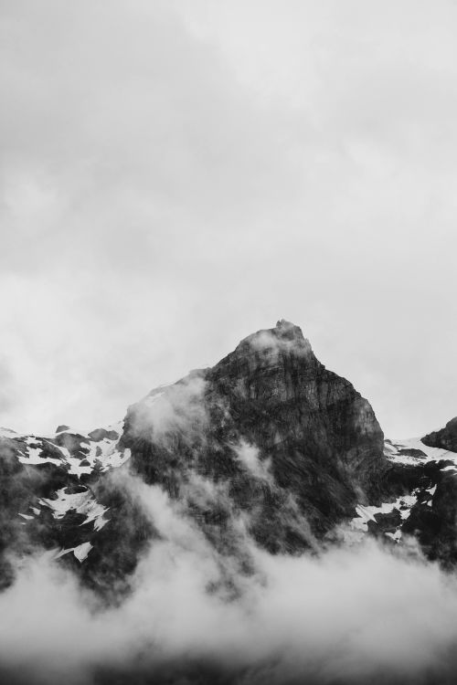 Free Stunning monochrome view of a snowcapped mountain peak shrouded in clouds in Sixt-Fer-à-Cheval, France. Stock Photo