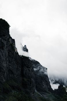 Mystical mist-covered mountain peaks in Sixt-Fer-à-Cheval, France. Captures the grandeur of untouched nature.