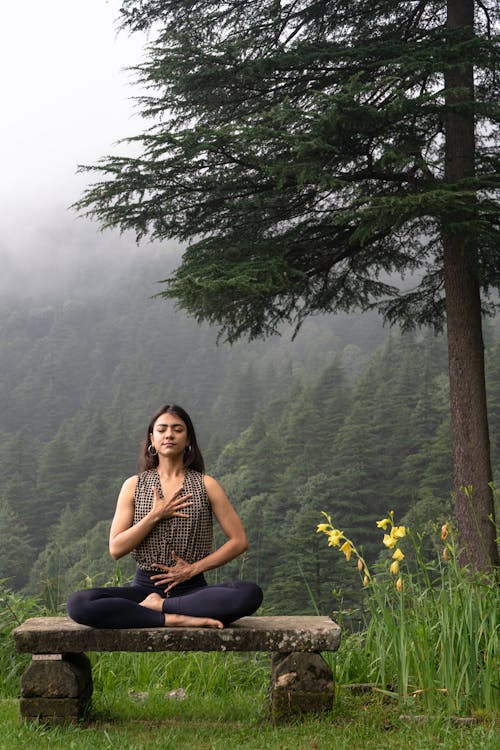 woman yoga pose with fog and forest in background