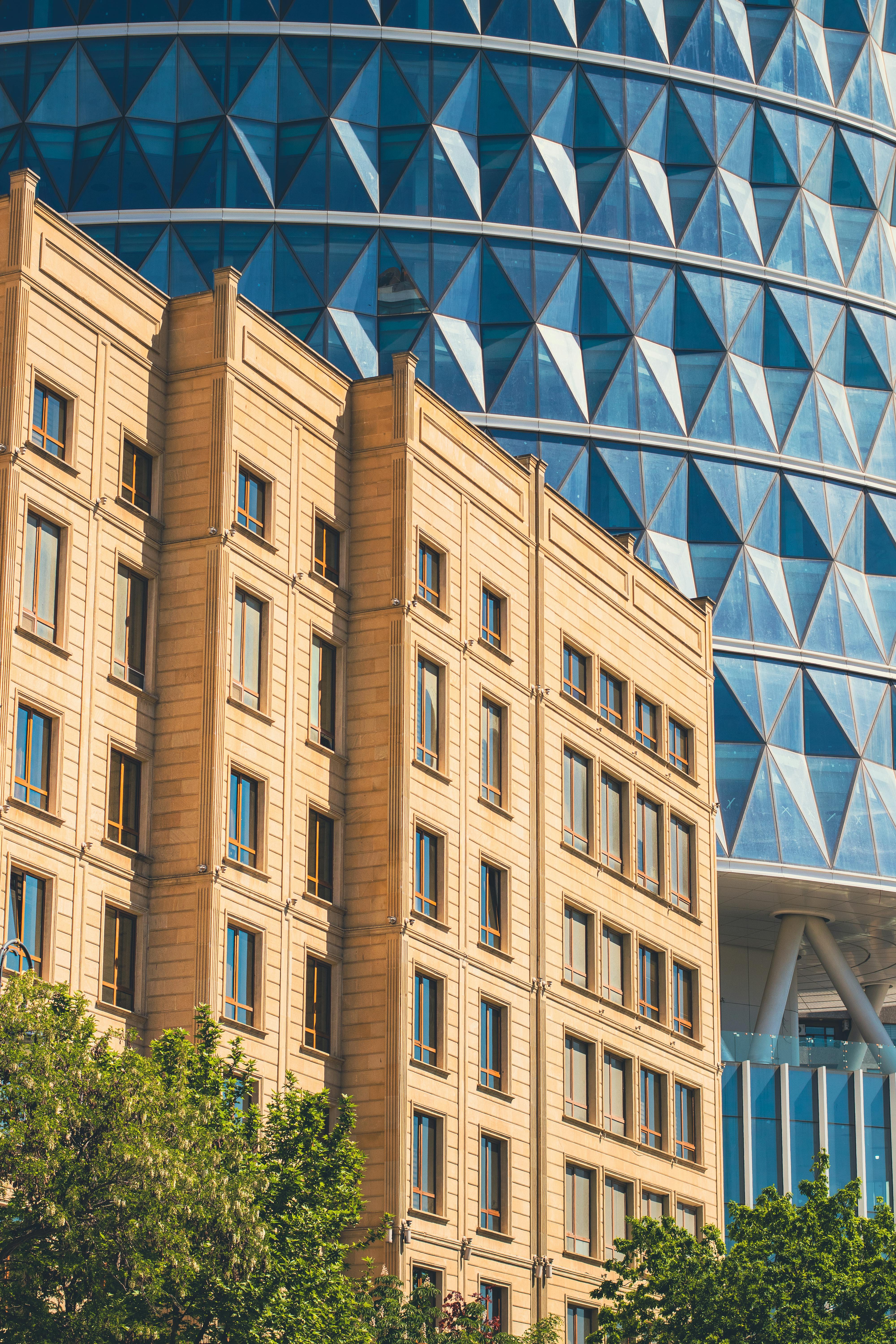 Contrast between a modern glass facade and historic building architecture.