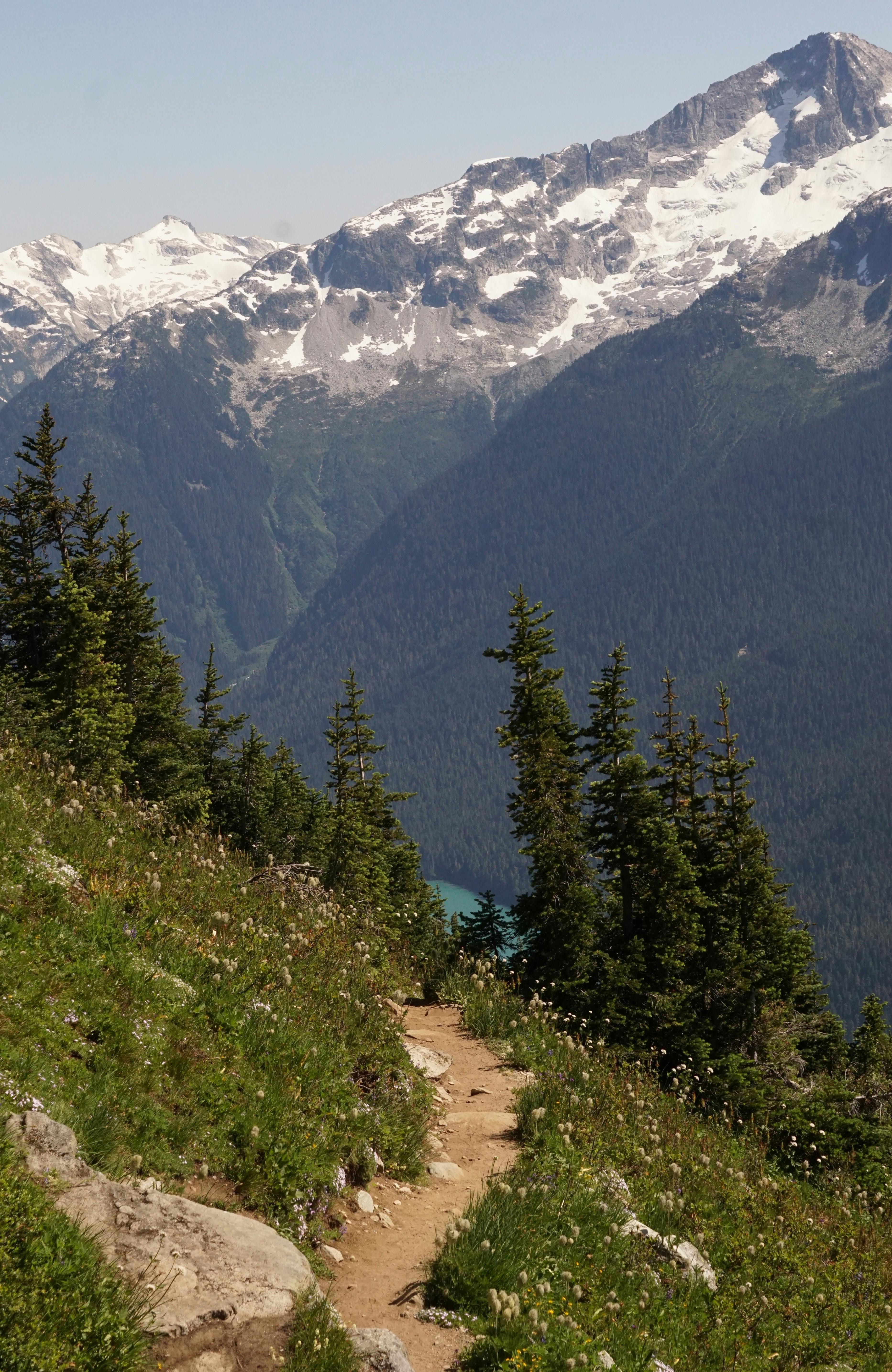 Explore the breathtaking mountain trail in Whistler, BC, with snow-capped peaks and lush forest views.