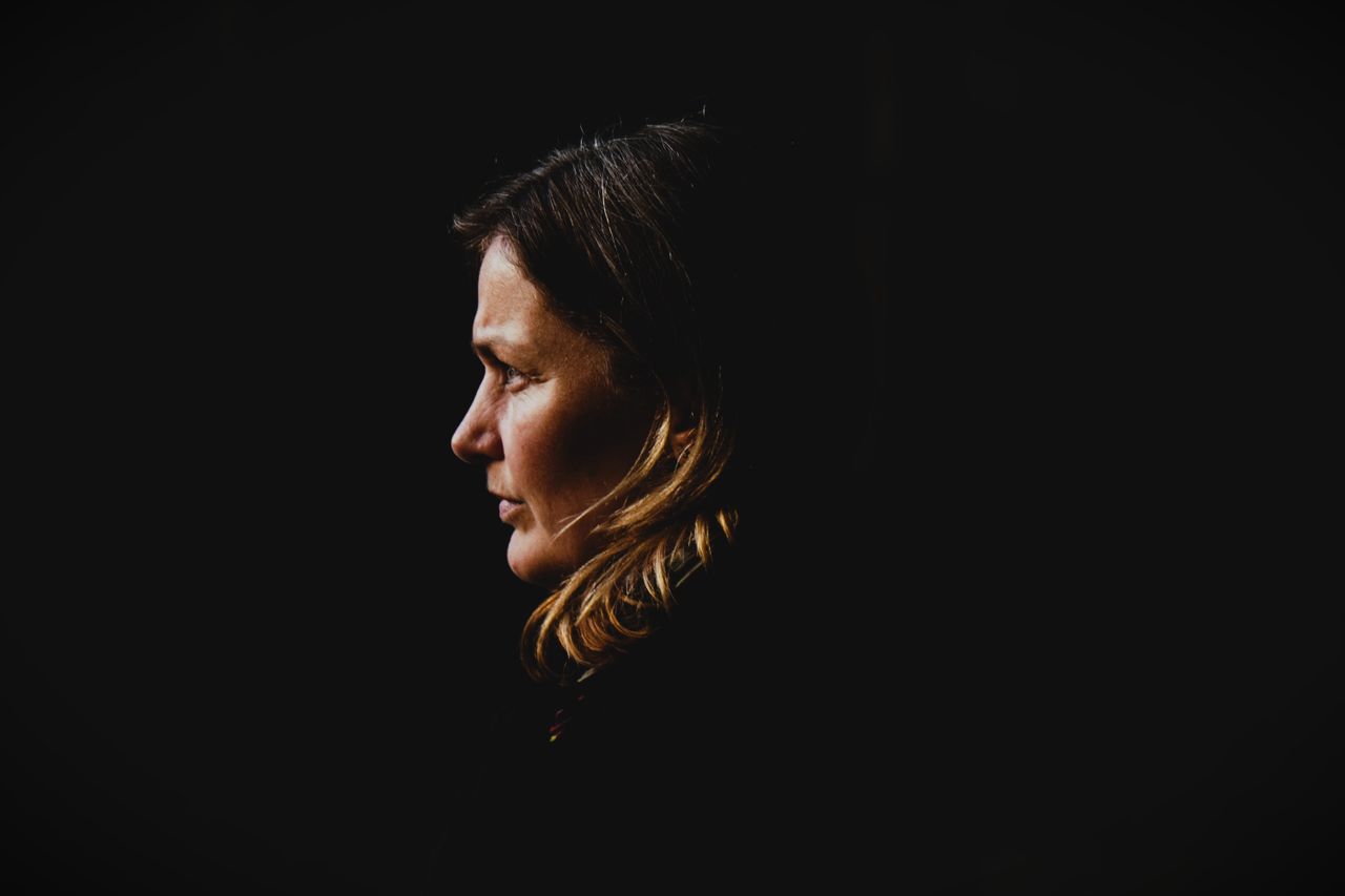 side profile portrait of a woman with dark background capturing intros