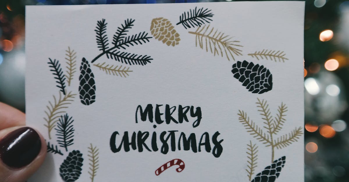 Person Holding Beige and Black Floral Merry Christmas Card