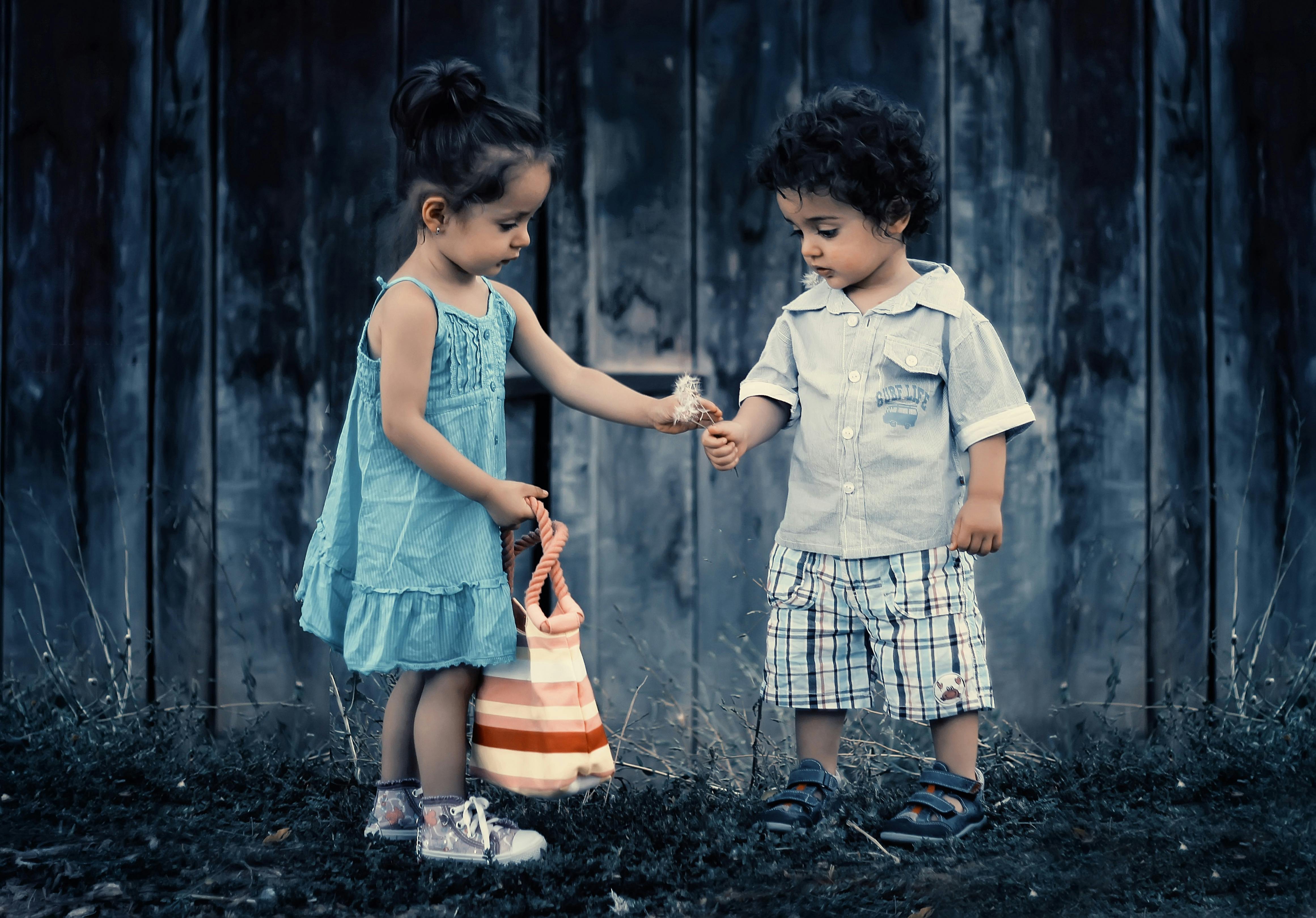 Boy and girl standing near the wall | Photo: Pexels