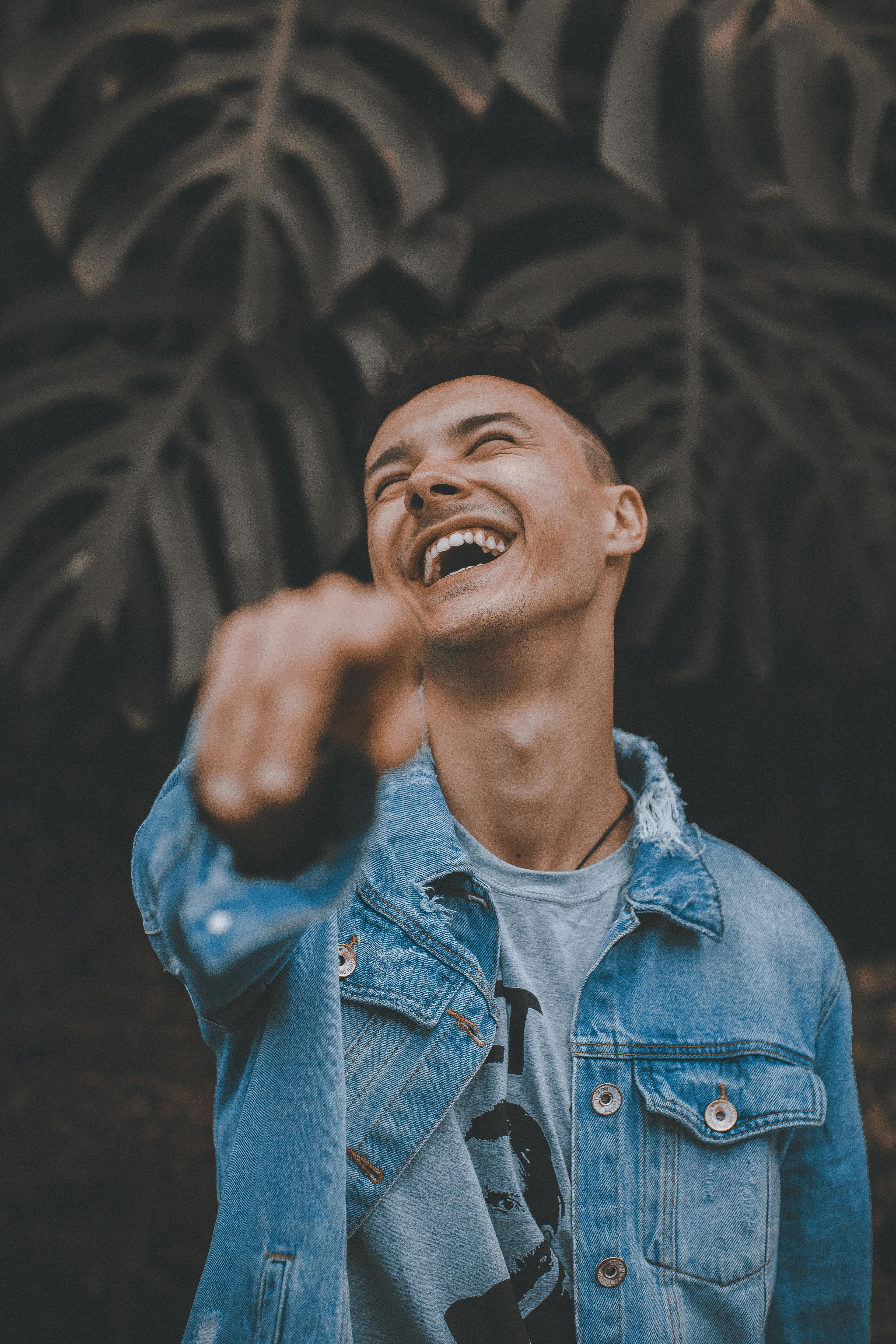 Man laughing while pointing his finger. | Photo: Pexels