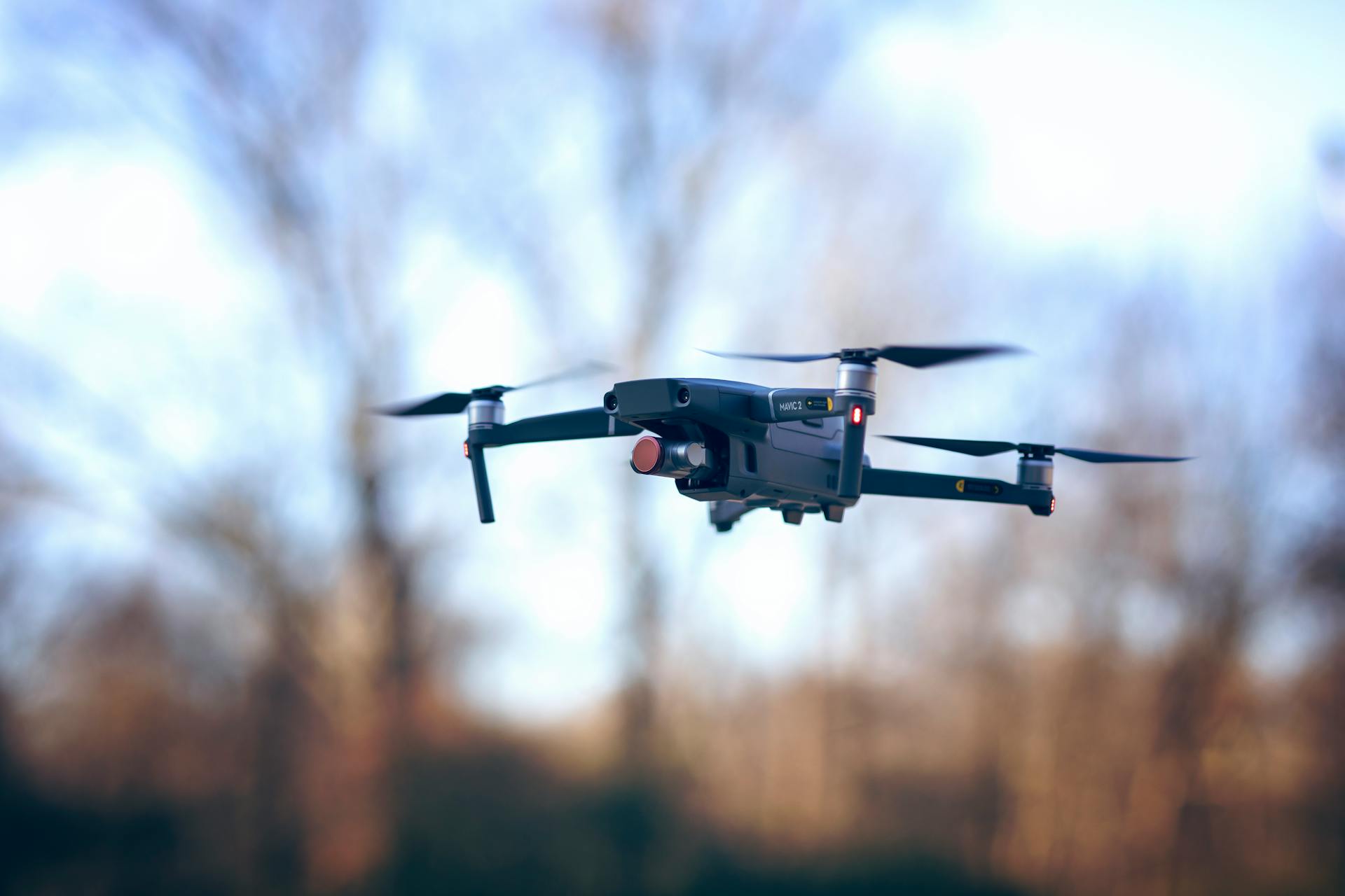 A sleek drone floats effortlessly against a daytime sky. Perfect for aerial photography enthusiasts.