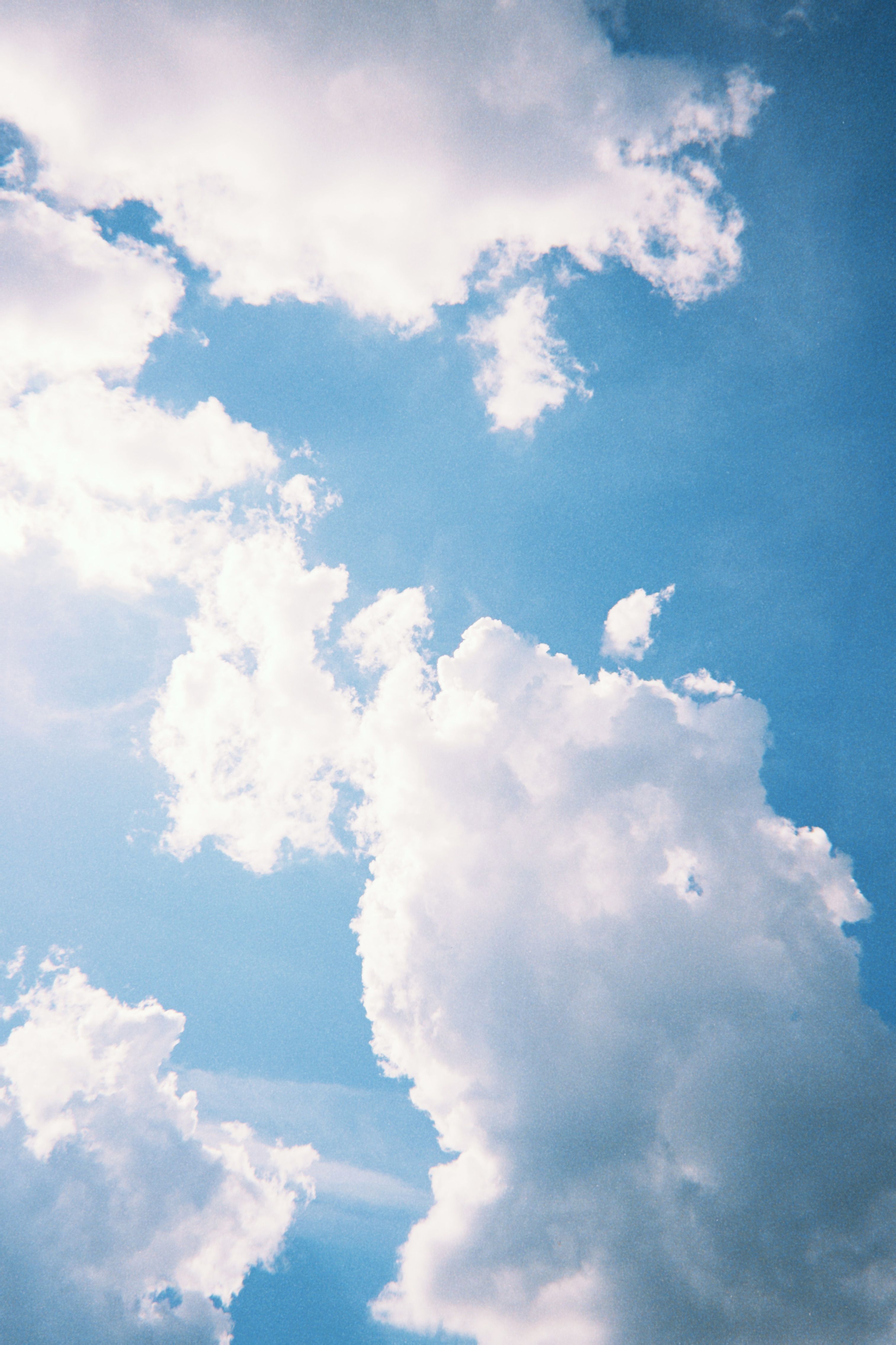 Bright and dramatic cloudscape over Poznań, Poland, showcasing fluffy white clouds against a blue sky.