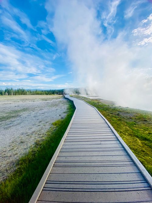 Free A picturesque boardwalk amidst geothermal steam at Yellowstone National Park. Stock Photo
