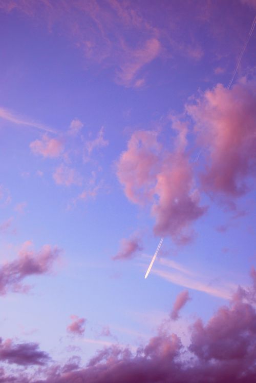 Free Capture of a purple sky with clouds and contrail during sunset, evoking tranquility and beauty. Stock Photo