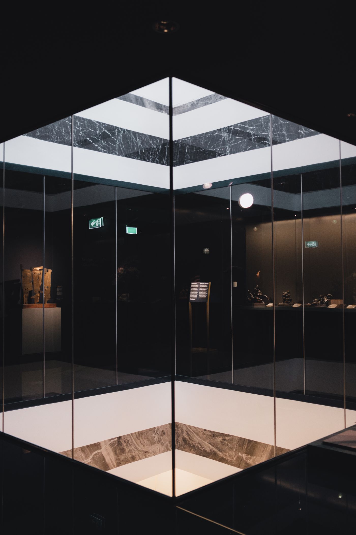 Geometric mirrors inside a dark, empty museum interior