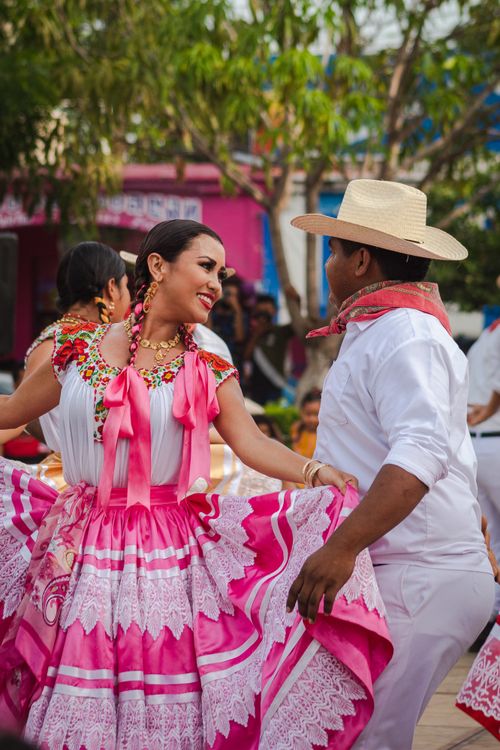 Free Joyful Mexican dancers in vibrant traditional attire at a lively outdoor festival. Stock Photo